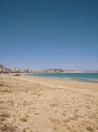 Scenic view of beach against clear blue sky