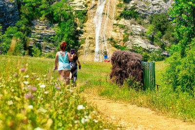 Rear view of couple walking on footpath