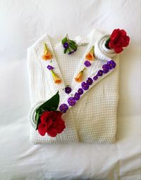 High angle view of colorful flowers on bathrobe over bed in room