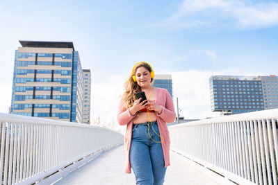 Young woman standing against buildings