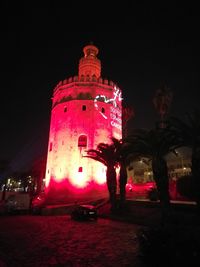 Low angle view of illuminated building against sky at night