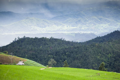 Scenic view of field and mountains against sky