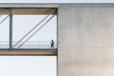 Low angle view of woman standing against built structure