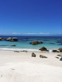 Scenic view of beach against clear blue sky