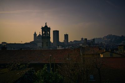 Buildings against sky during sunset in city