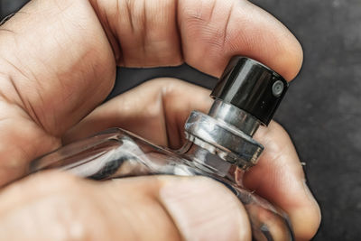Cropped hand of man holding perfume sprayer