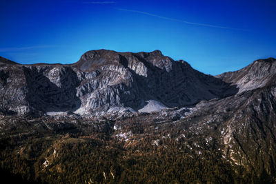 Low angle view of mountains against clear blue sky