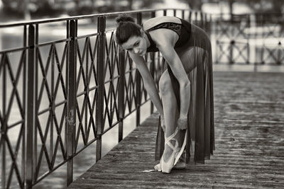 Young woman sitting on railing