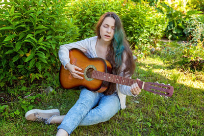 Portrait of young woman sitting on field