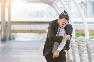 Mid adult businessman wearing blazer on elevated walkway