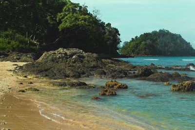 Scenic view of rocks in sea against sky