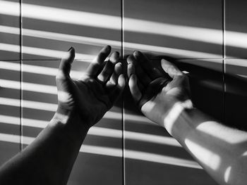 Close-up of hands on floor against wall