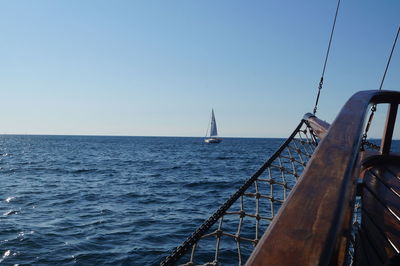 Sailboat sailing on sea against clear sky