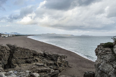 Rocks at beach against sky