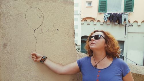 Optical illusion of woman holding balloon drawn on wall