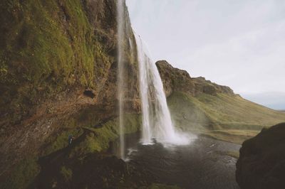 Low angle view of waterfall against sky