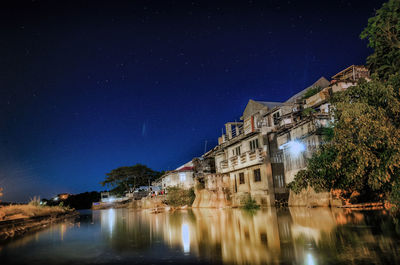 Reflection of illuminated buildings on calm river at night