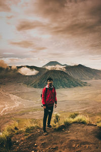 Full length of man standing on mountain against sky