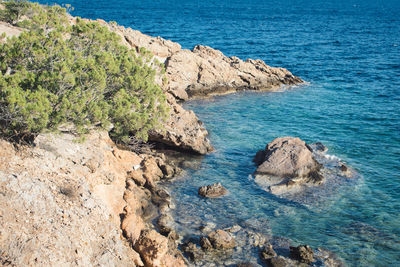 High angle view of rocks on sea shore