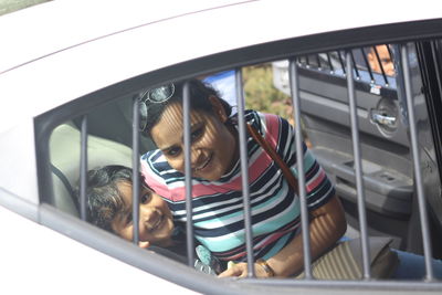 High angle portrait of mother and son sitting in vehicle