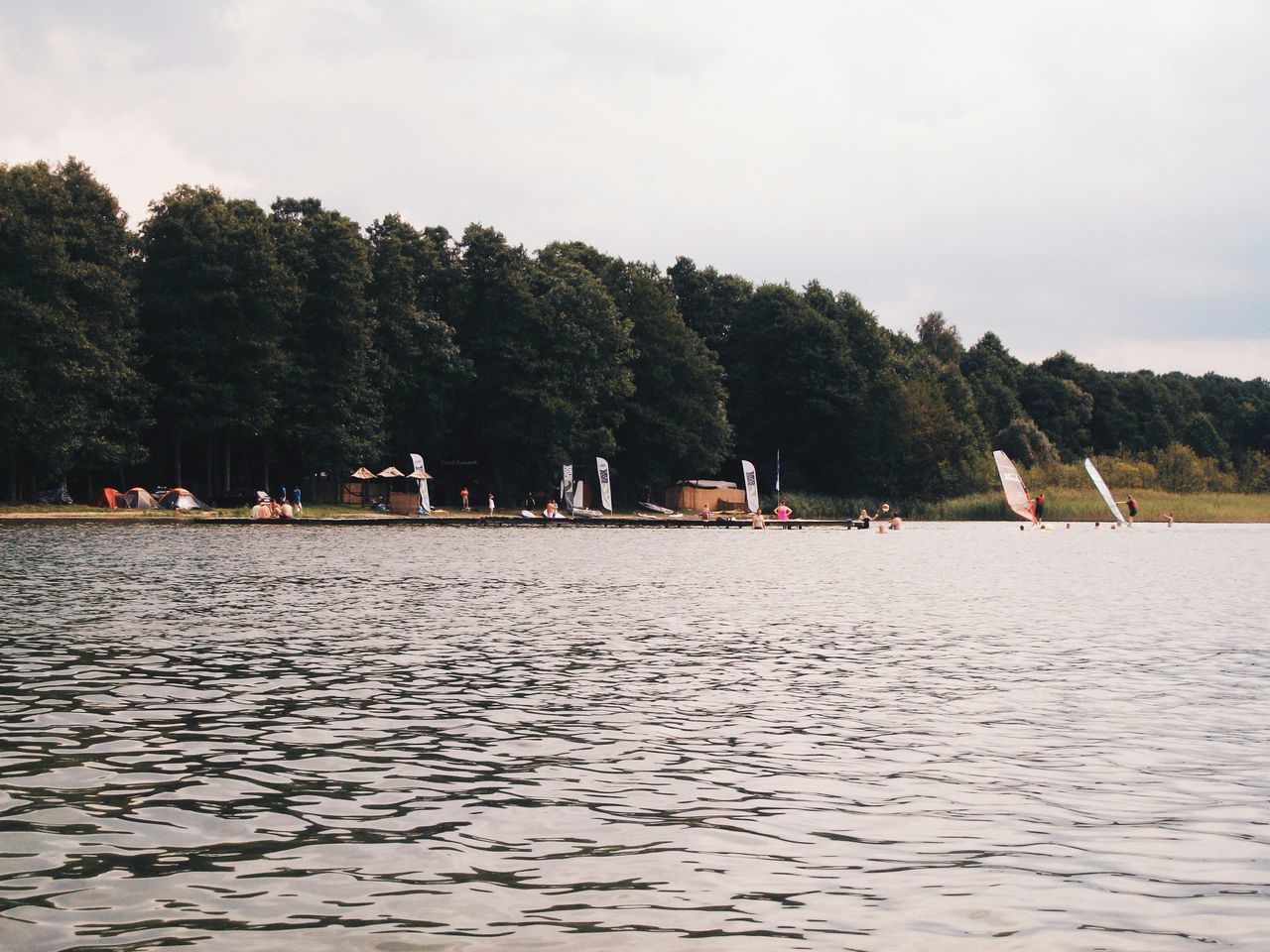 tree, water, waterfront, tranquil scene, sky, rippled, tranquility, scenics, nature, beauty in nature, large group of people, lake, incidental people, men, river, day, sea, mid distance, vacations