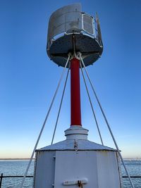 Low angle view of crane against clear blue sky