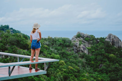 Rear view of woman looking at sea while standing on observation point