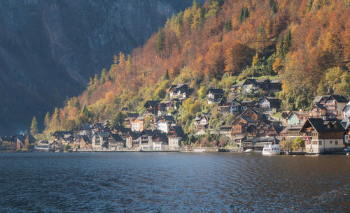 Scenic view of townscape by tree mountain during autumn