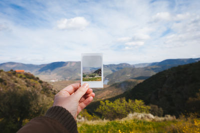 Man taking picture of a mountain range