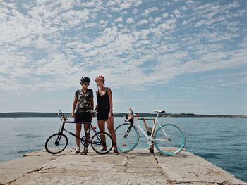 Bicycles on bicycle by sea against sky