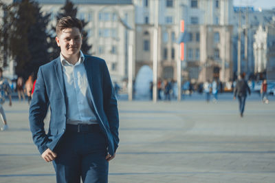 Young businessman standing in city