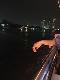 Man on illuminated boat against sky at night