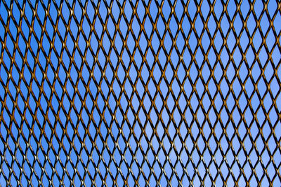 Metal fence background, real fence close-up and texture on the white sky background and texture