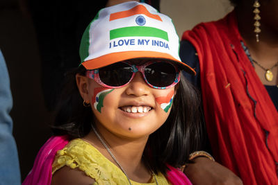 Portrait of an indian girl child wearing tri-color cap and indian flag painted on cheeks