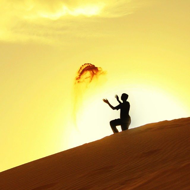 silhouette, sunset, leisure activity, lifestyles, men, full length, sky, copy space, low angle view, jumping, mid-air, desert, nature, side view, unrecognizable person, sunlight, outdoors, orange color