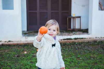 Portrait of young woman holding apple at park