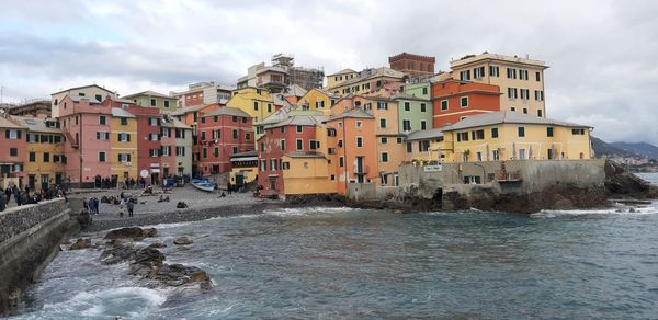 Buildings by sea against sky in city