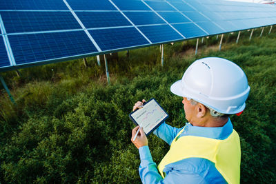 High angle view of engineer using tablet for setting solar system. eco concept