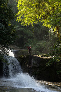 A male traveller exploring the beautiful of rain forest waterfall. 