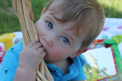 Close-up portrait of cute boy biting wicker