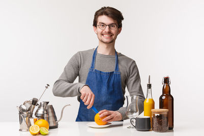 Portrait of smiling man holding ice cream over white background