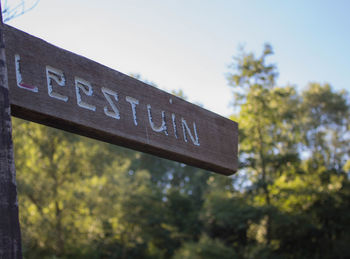 Close-up of information sign against trees