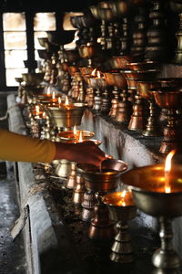 Cropped hand of woman holding illuminated lanterns