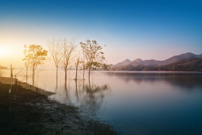 Scenic view of lake against blue sky during sunset