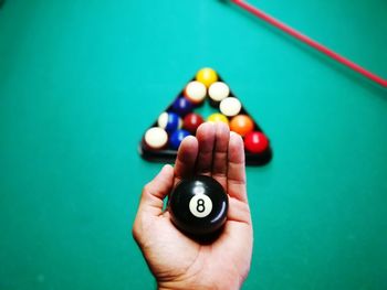 High angle view of man holding pool ball