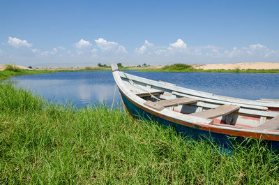 Boat moored in lake against sky