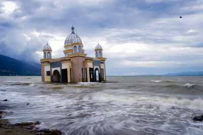 Church by sea against sky