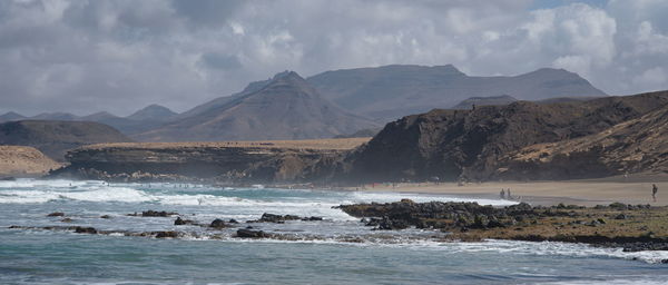 Scenic view of sea and mountains against sky