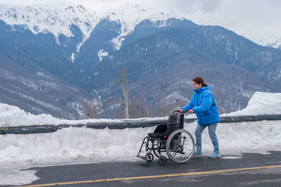 Rear view of man walking on snowcapped mountain