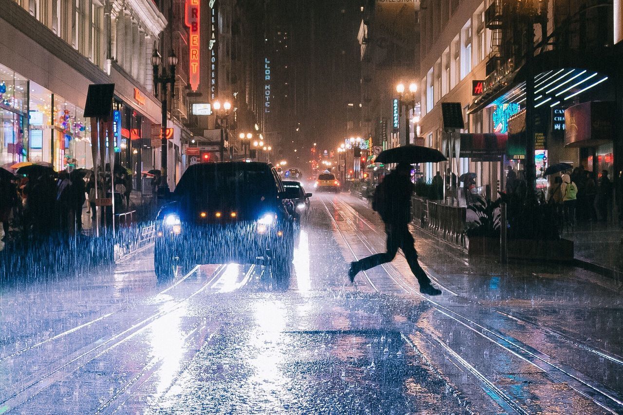 illuminated, street, city, night, wet, building exterior, city life, rain, architecture, built structure, walking, transportation, city street, lifestyles, car, men, person, road